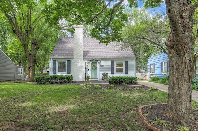 5608 Outlook St, Mission, KS 66202 - new england style home featuring a front lawn, a chimney, and a shingled roof