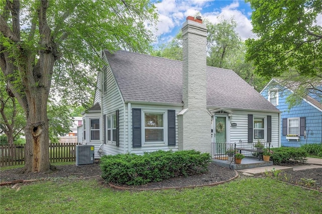 5608 Outlook St, Mission, KS 66202 - new england style home featuring central AC, a chimney, and roof with shingles