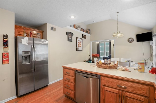 13825 Woodmont Ave, Bonner Springs, KS 66012 - kitchen featuring stainless steel appliances, light countertops, light wood-type flooring, a chandelier, and brown cabinetry