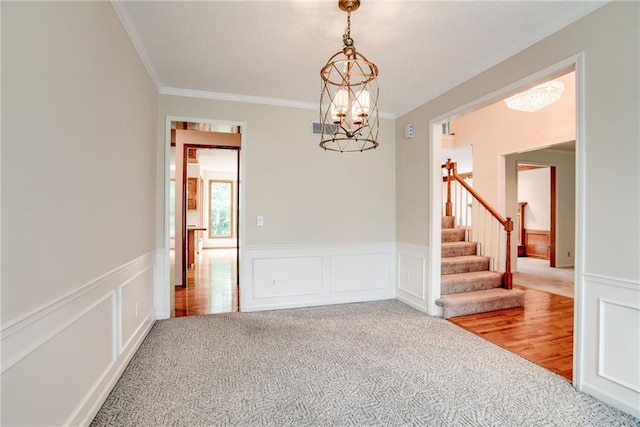 16482 W 132nd Cir, Olathe, KS 66062 - carpeted empty room featuring crown molding, a chandelier, stairs, wainscoting, and a decorative wall