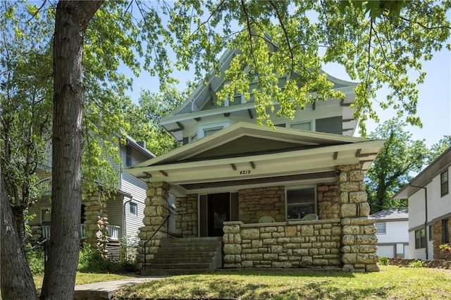 4219 Kenwood Ave, Kansas City, MO 64110 - american foursquare style home featuring a porch and stone siding