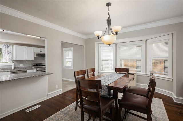 4219 Kenwood Ave, Kansas City, MO 64110 - dining space with crown molding and dark wood-style flooring