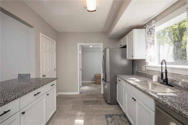 4219 Kenwood Ave, Kansas City, MO 64110 - kitchen with stainless steel appliances, white cabinets, and light stone counters