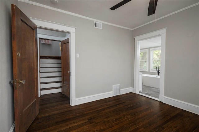 4219 Kenwood Ave, Kansas City, MO 64110 - unfurnished room featuring ceiling fan, dark wood-type flooring, ornamental molding, and stairway