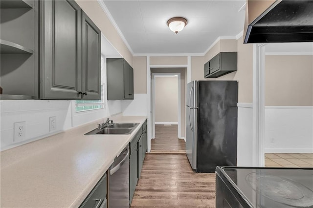 712 NE 45th St, Kansas City, MO 64116 - kitchen with stainless steel appliances, a sink, wall chimney range hood, light wood-type flooring, and light countertops