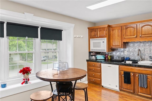 15205 E 40th St S, Independence, MO 64055 - kitchen with white appliances, a sink, backsplash, light wood-type flooring, and brown cabinets