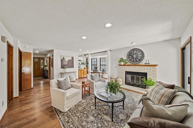 12332 W 105th Ter, Overland Park, KS 66215 - living room with a textured ceiling, wood finished floors, a fireplace, recessed lighting, and baseboards
