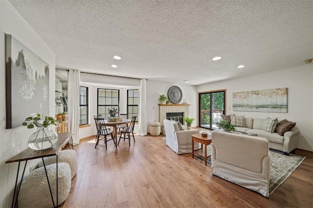 12332 W 105th Ter, Overland Park, KS 66215 - living area with a textured ceiling, wood finished floors, recessed lighting, and a brick fireplace