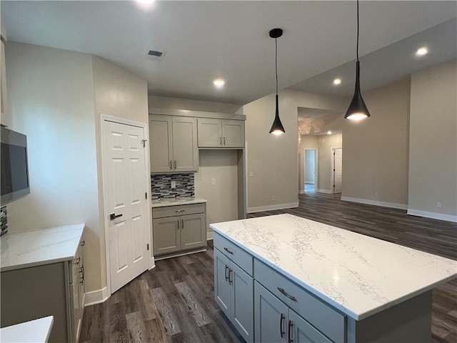 2320 NE 72nd St, Kansas City, MO 64118 - kitchen featuring gray cabinets, dark wood-style flooring, light stone counters, decorative backsplash, and recessed lighting