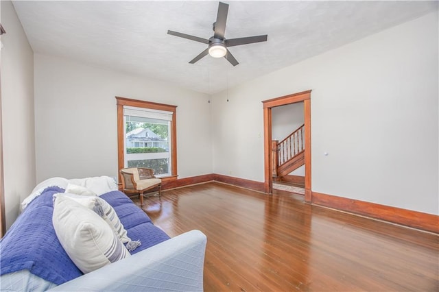 915 Main St, Neodesha, KS 66757 - living area featuring wood finished floors, a ceiling fan, stairs, and baseboards