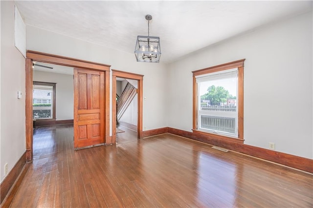 915 Main St, Neodesha, KS 66757 - unfurnished room with hardwood / wood-style floors, a chandelier, and baseboards