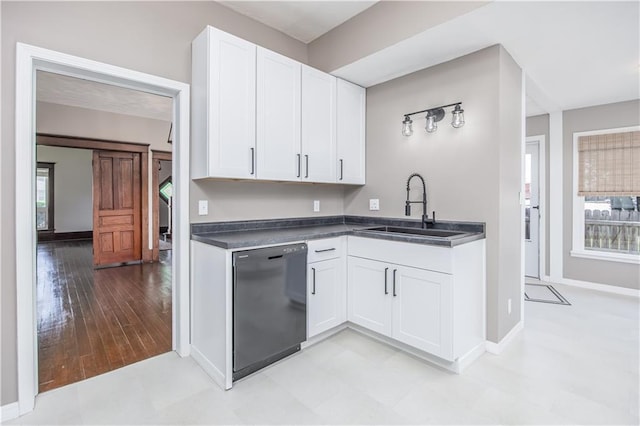 915 Main St, Neodesha, KS 66757 - kitchen featuring dishwasher, a sink, dark countertops, white cabinets, and baseboards