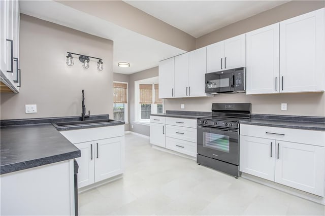 915 Main St, Neodesha, KS 66757 - kitchen featuring black appliances, dark countertops, a sink, white cabinets, and light floors