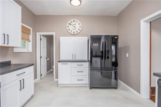 915 Main St, Neodesha, KS 66757 - kitchen with freestanding refrigerator, baseboards, dark countertops, and light floors