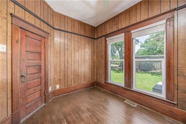 915 Main St, Neodesha, KS 66757 - empty room featuring hardwood / wood-style floors and wood walls