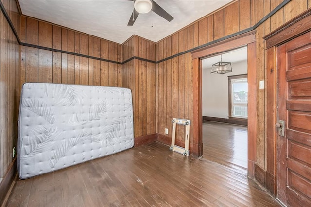 915 Main St, Neodesha, KS 66757 - unfurnished room with wood walls, hardwood / wood-style floors, ceiling fan, and a chandelier