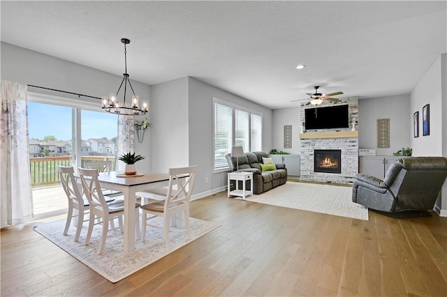 19629 W 196th St, Spring Hill, KS 66083 - dining room featuring a fireplace, a ceiling fan, hardwood / wood-style floors, baseboards, and a chandelier