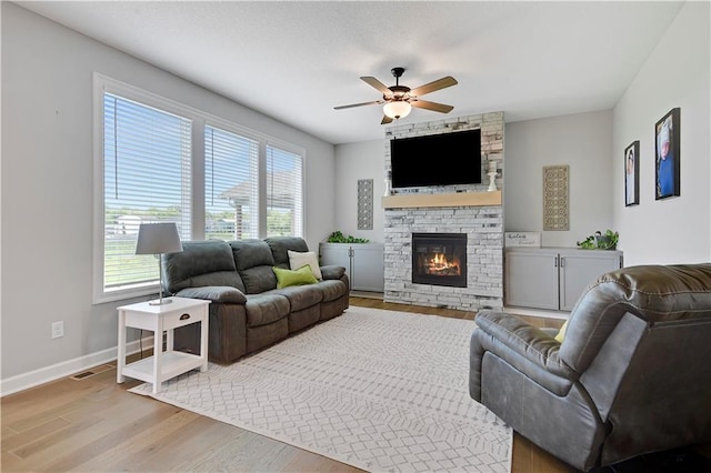 19629 W 196th St, Spring Hill, KS 66083 - living room with wood finished floors, ceiling fan, baseboards, and a stone fireplace