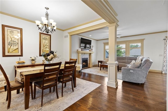 24318 W 91st Pl, Lenexa, KS 66227 - dining area with crown molding, a lit fireplace, dark wood-style flooring, decorative columns, and a chandelier
