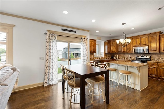 24318 W 91st Pl, Lenexa, KS 66227 - kitchen featuring appliances with stainless steel finishes, brown cabinets, a chandelier, a sink, and tasteful backsplash