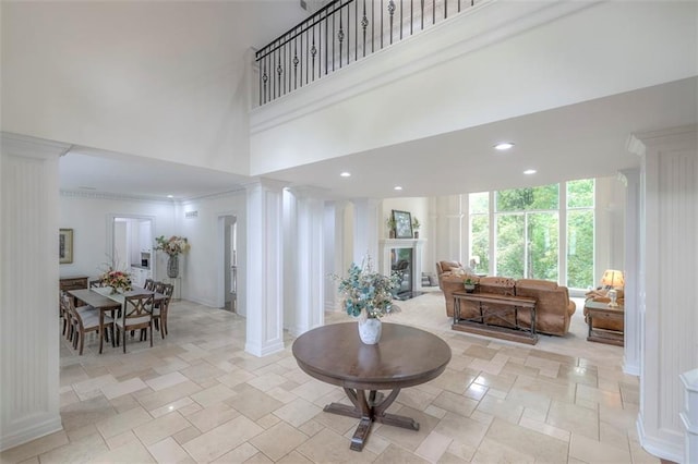 3109 W 118th St, Leawood, KS 66211 - living room with ornate columns, a high ceiling, light stone finish flooring, and recessed lighting