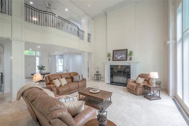 3109 W 118th St, Leawood, KS 66211 - living room with decorative columns, a towering ceiling, a ceiling fan, light carpet, and a tiled fireplace