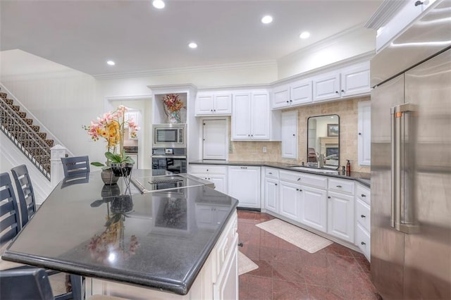 3109 W 118th St, Leawood, KS 66211 - kitchen featuring built in appliances, white cabinets, crown molding, a kitchen island, and granite tiled floors