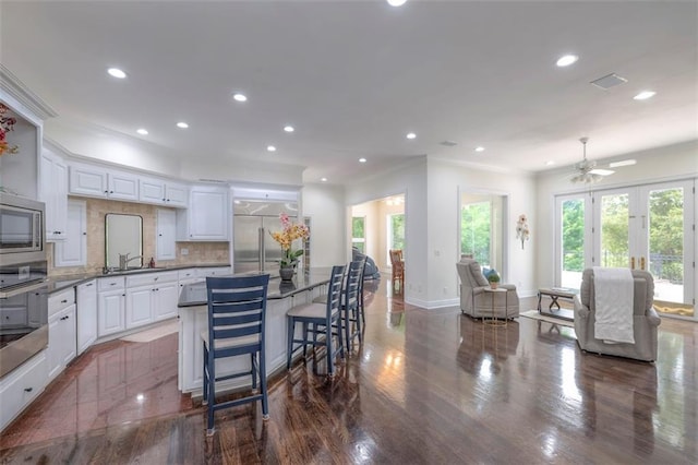 3109 W 118th St, Leawood, KS 66211 - kitchen with built in appliances, crown molding, recessed lighting, white cabinets, and tasteful backsplash