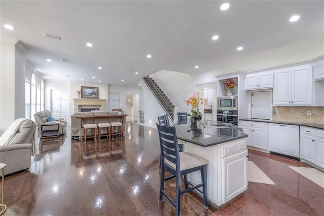 3109 W 118th St, Leawood, KS 66211 - kitchen featuring stainless steel appliances, crown molding, open floor plan, a fireplace, and white cabinets