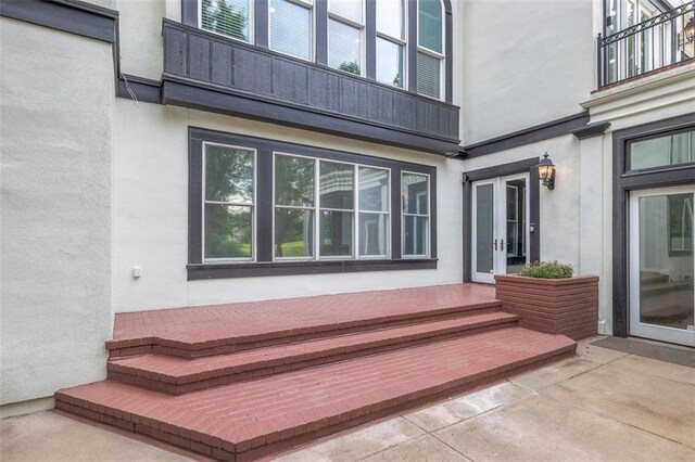 3109 W 118th St, Leawood, KS 66211 - property entrance featuring stucco siding, a balcony, french doors, and a patio