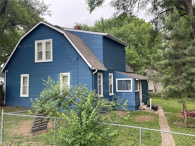 2302 3rd Ave, Leavenworth, KS 66048 - view of home's exterior featuring a shingled roof, a chimney, entry steps, and a gambrel roof