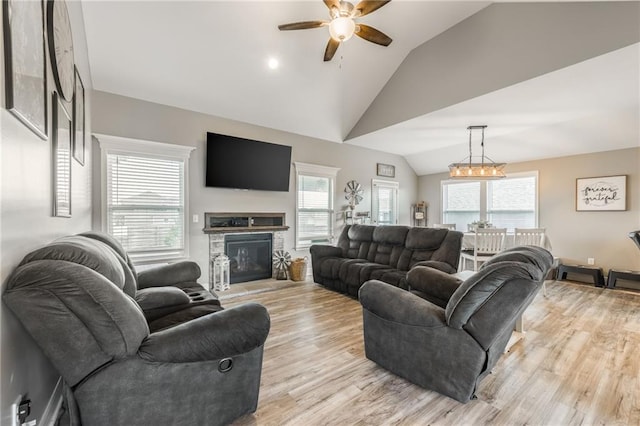 2808 E Cedar Pl, Tonganoxie, KS 66086 - living room featuring lofted ceiling, ceiling fan, light wood-style floors, and a stone fireplace