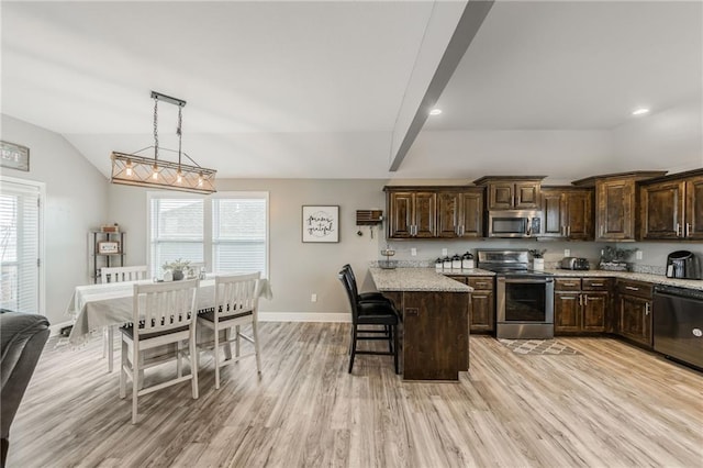 2808 E Cedar Pl, Tonganoxie, KS 66086 - kitchen with stainless steel appliances, dark brown cabinets, a breakfast bar, light wood finished floors, and baseboards