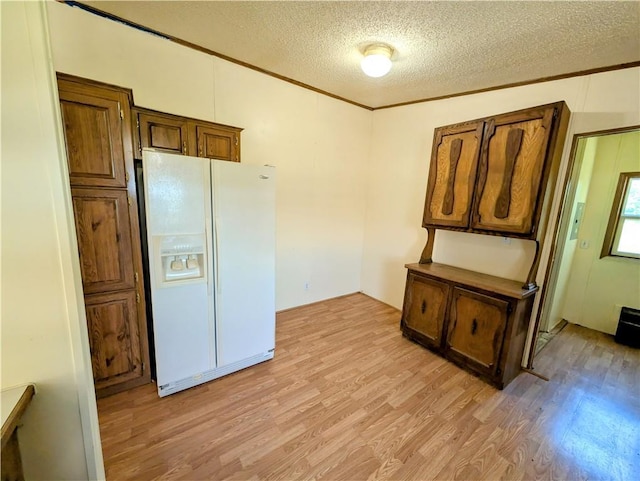 kitchen featuring white fridge with ice dispenser, light wood-style floors, a textured ceiling, and ornamental molding