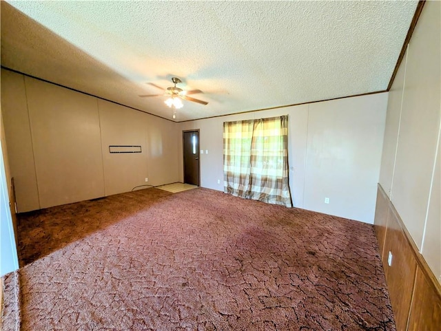 spare room featuring carpet flooring, ceiling fan, a textured ceiling, and a decorative wall