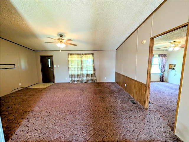 carpeted spare room with ceiling fan and a textured ceiling