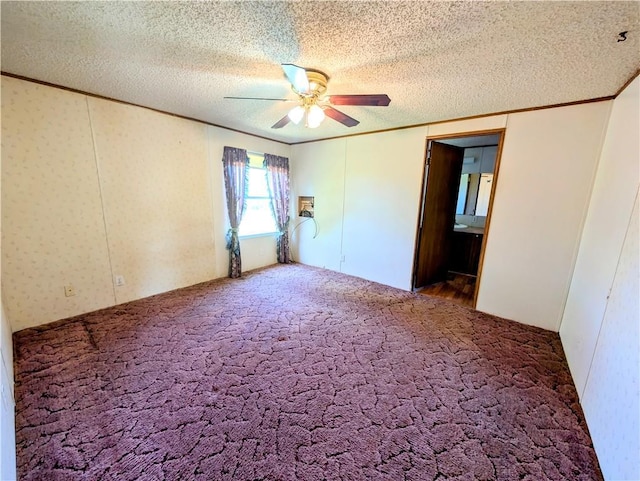unfurnished room featuring ornamental molding, ceiling fan, carpet flooring, and a textured ceiling