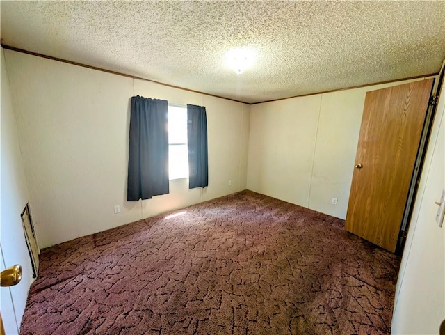 unfurnished room with carpet floors and a textured ceiling
