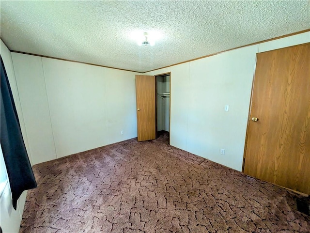 unfurnished bedroom featuring carpet, a textured ceiling, and a closet