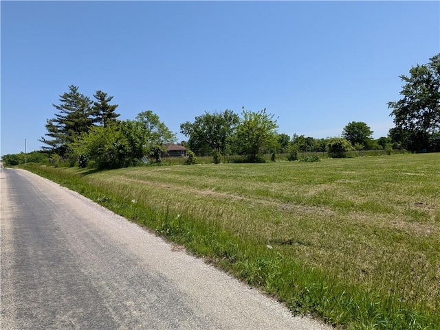 view of asphalt street featuring a rural view