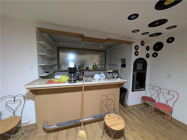 kitchen featuring open shelves, wood finished floors, and baseboards