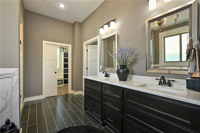16812 Gillette St, Overland Park, KS 66221 - bathroom with double vanity, a chandelier, and baseboards