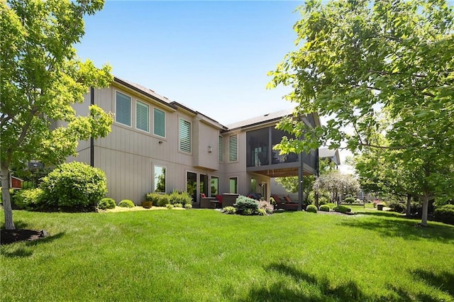 16812 Gillette St, Overland Park, KS 66221 - rear view of house featuring a lawn and a sunroom
