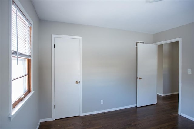 15402 E 37th Ter, Independence, MO 64055 - unfurnished bedroom with baseboards, multiple windows, and dark wood-style flooring
