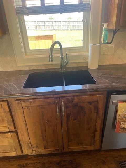 21162 147th St, Basehor, KS 66007 - kitchen view of dark countertops, a sink, stainless steel dishwasher, and brown cabinets