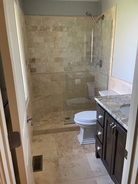 21162 147th St, Basehor, KS 66007 - bathroom featuring toilet, vanity, and a tile shower