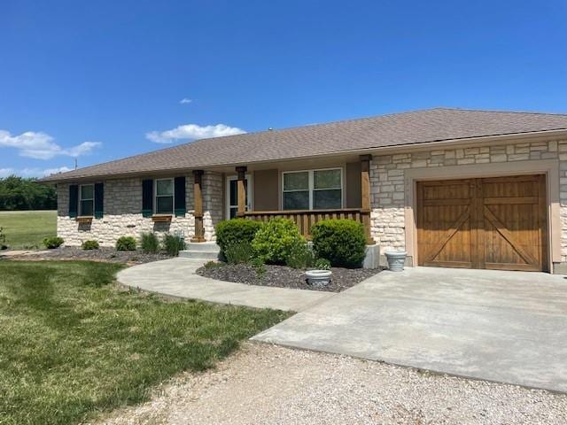 21162 147th St, Basehor, KS 66007 - ranch-style home with stone siding, concrete driveway, a garage, a front yard, and covered porch