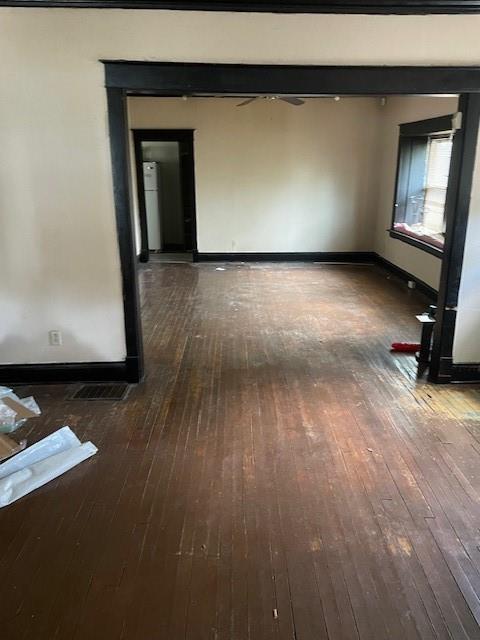 spare room with wood-type flooring and baseboards