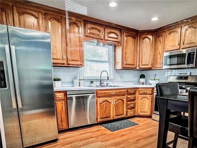 6404 N Harrison St, Oakview, MO 64118 - kitchen with stainless steel appliances, a sink, light countertops, light wood-style flooring, and recessed lighting