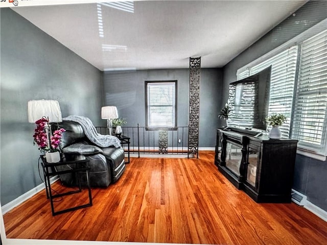 6404 N Harrison St, Oakview, MO 64118 - living area featuring wood finished floors, baseboards, and plenty of natural light